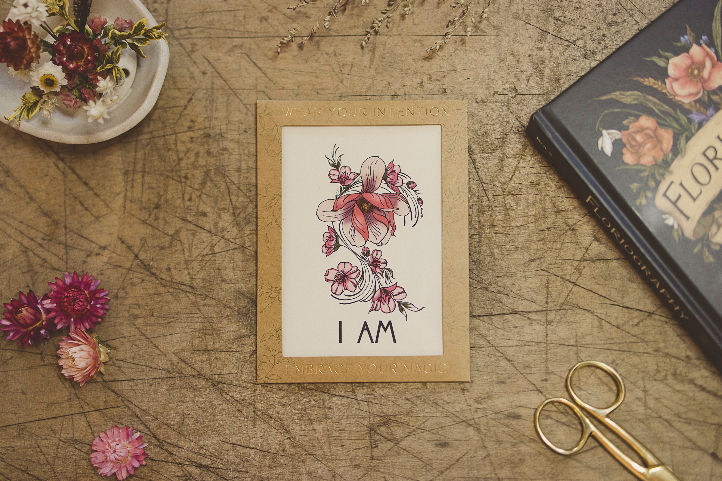 Detailed view of the "I Am" temporary tattoo script and fine magnolia flower illustration