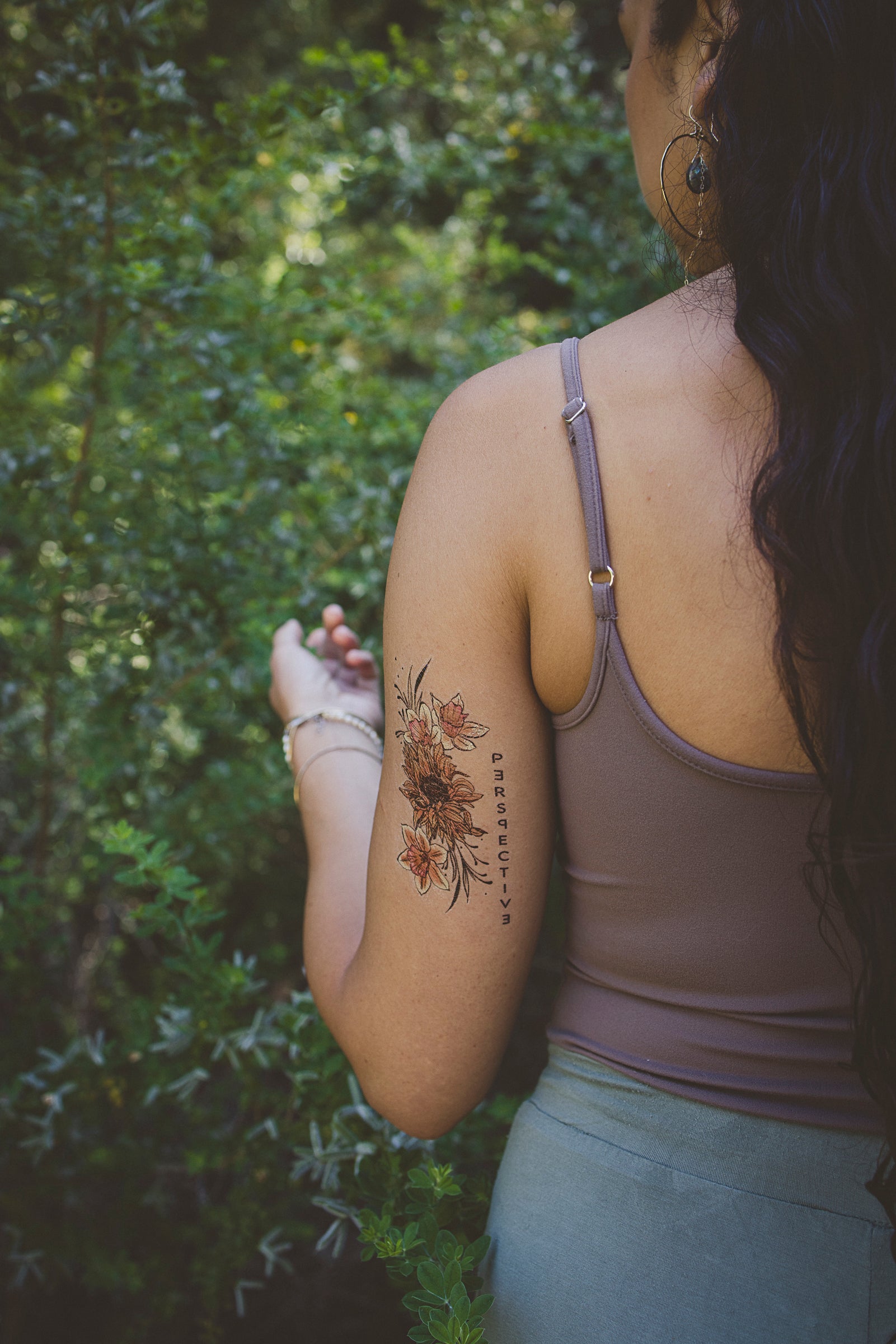Person wearing a "Perspective" botanical tattoo on their arm as a daily affirmation.