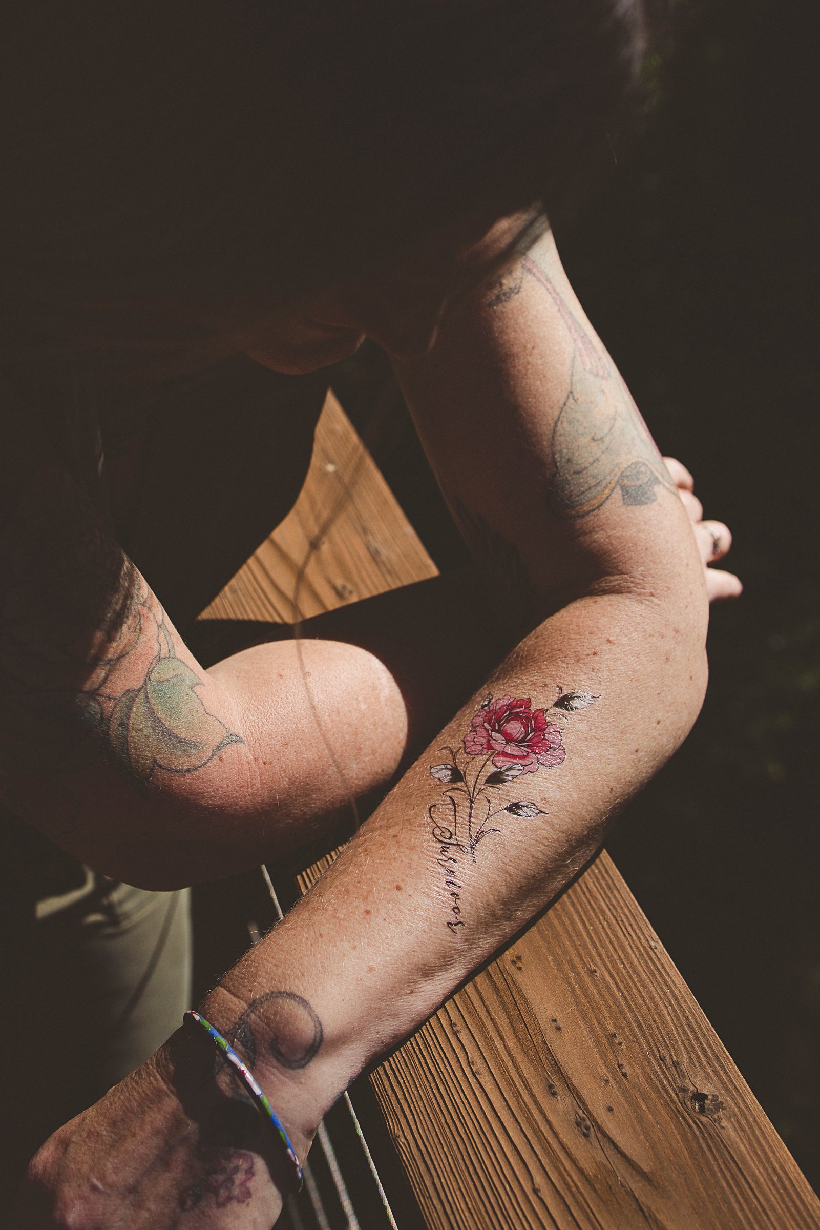 Person wearing a "Survivor" botanical tattoo on their arm as a daily affirmation
